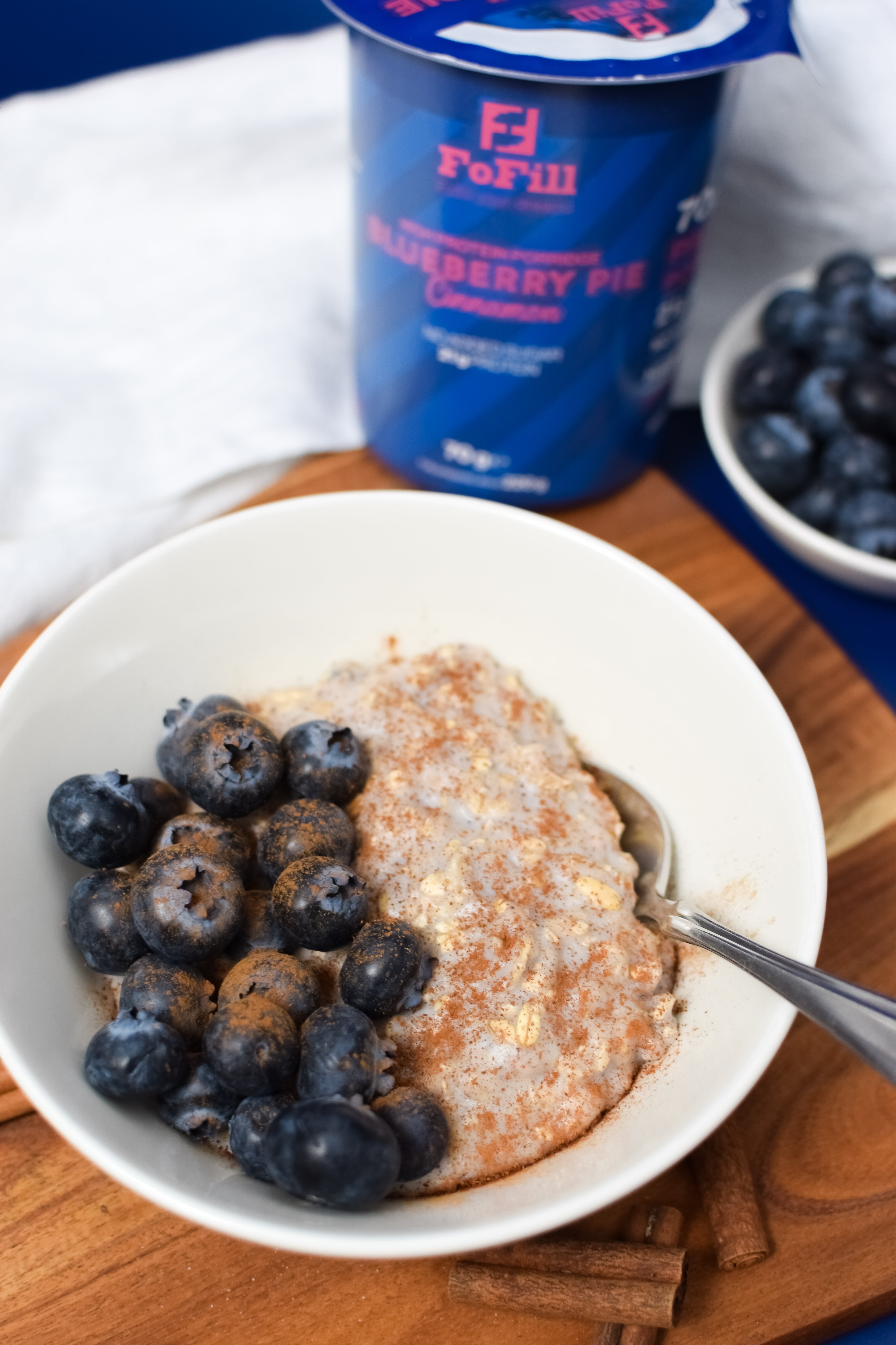 En skål Blueberry Pie Cinnamon Proteingröt toppad med färska blåbär och kanel. En hälsosam och proteinrik frukost eller mellanmål med 21 gram protein och utan tillsatt socker.